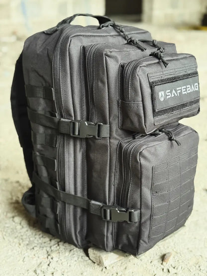 Black tactical backpack with visible 'SAFERAG' branding on a concrete surface.